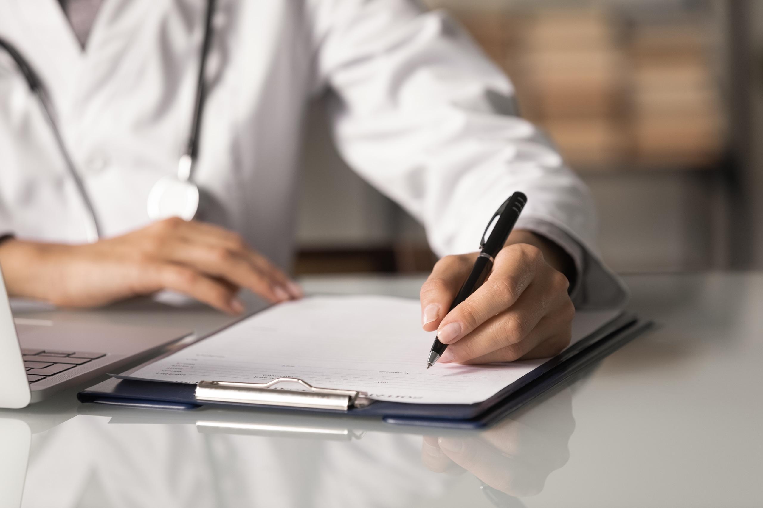 Close up of a medical professional filling out paperwork