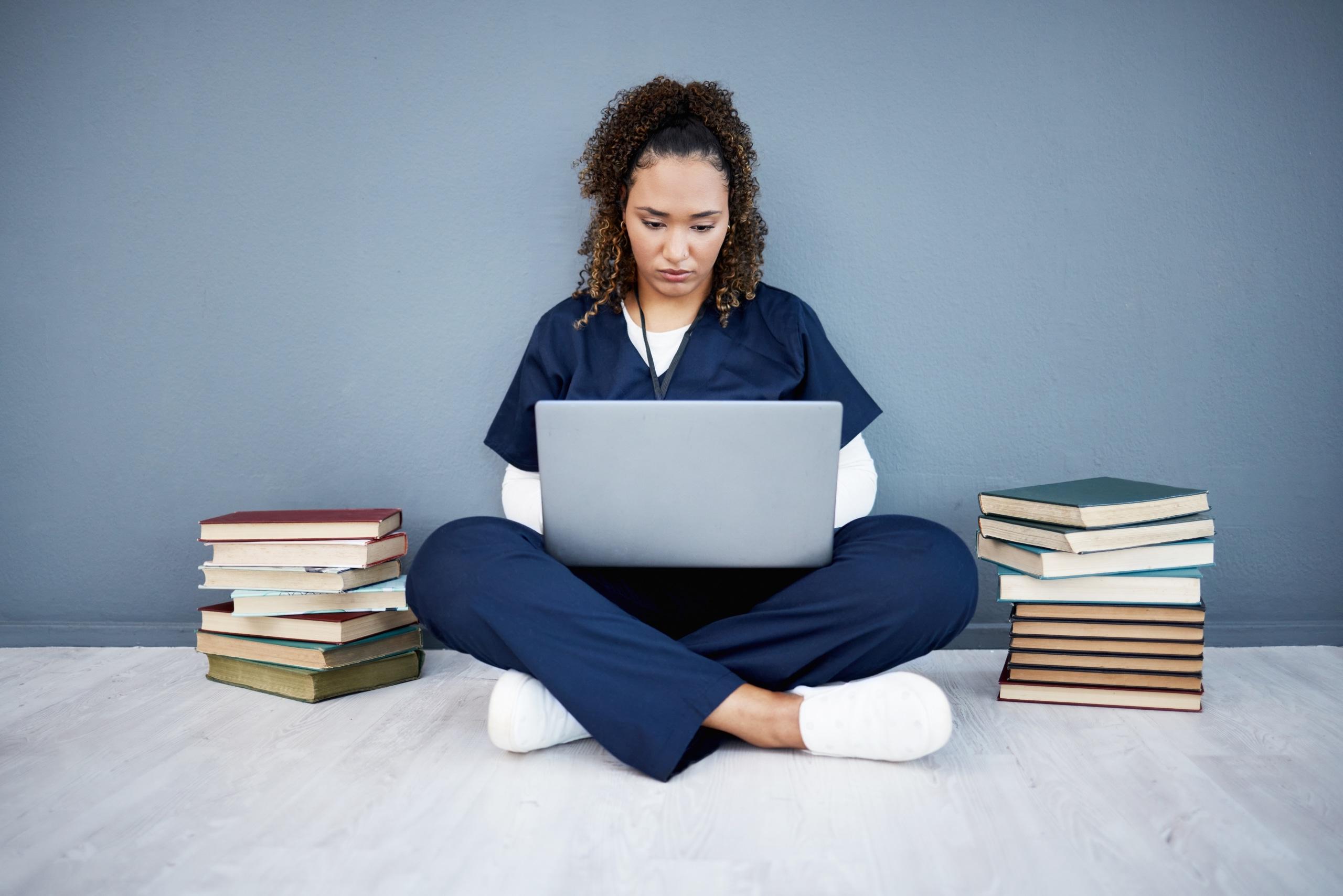 African-American nurse typing on a laptop